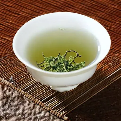 나무로 만들어진 차 깔개위에 흰색 컵에 담겨 있는 그윽한 녹색빛깔의 차 한잔