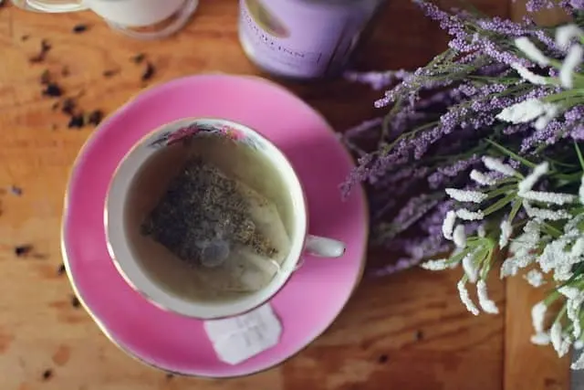 보라빛깔의 꽃과 라벤더티백이 들어가 있는 차 한잔