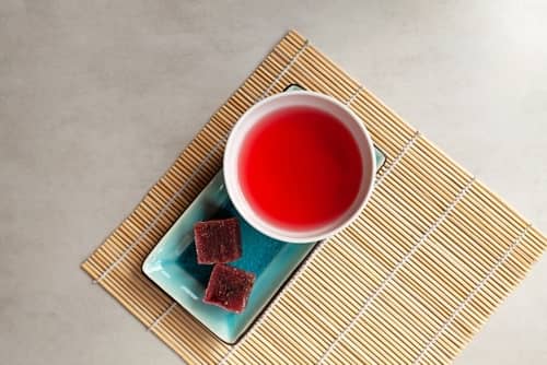 붉은 빛깔의 오미자차 한잔과 간식 두개
