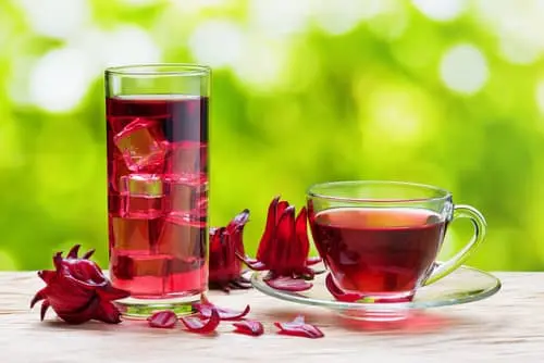 두잔의 유리잔에 얼음과 꽃잎이 함께들어가 있으며 빨간색의 영롱한 빛깔의 피부에 좋은 차 히비스커스